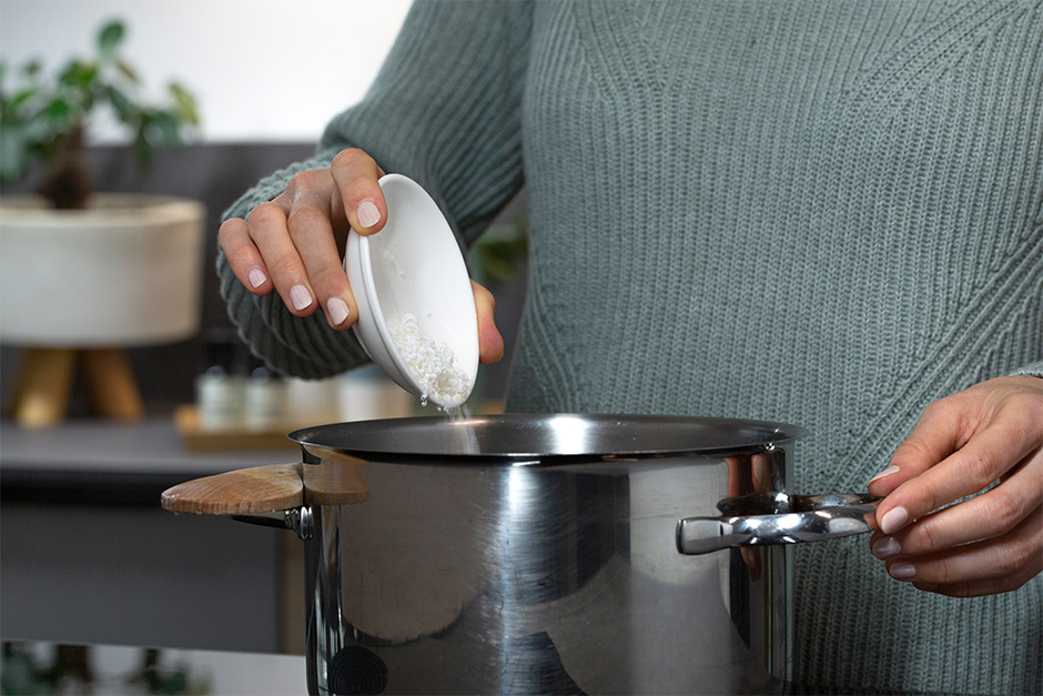 3. Erhitze 100 ml Wasser im Kochtopf und gib die feingehackten Seifenstücke hinzu. Rühre langsam immer wieder um, bis sich die Seife komplett aufgelöst hat.